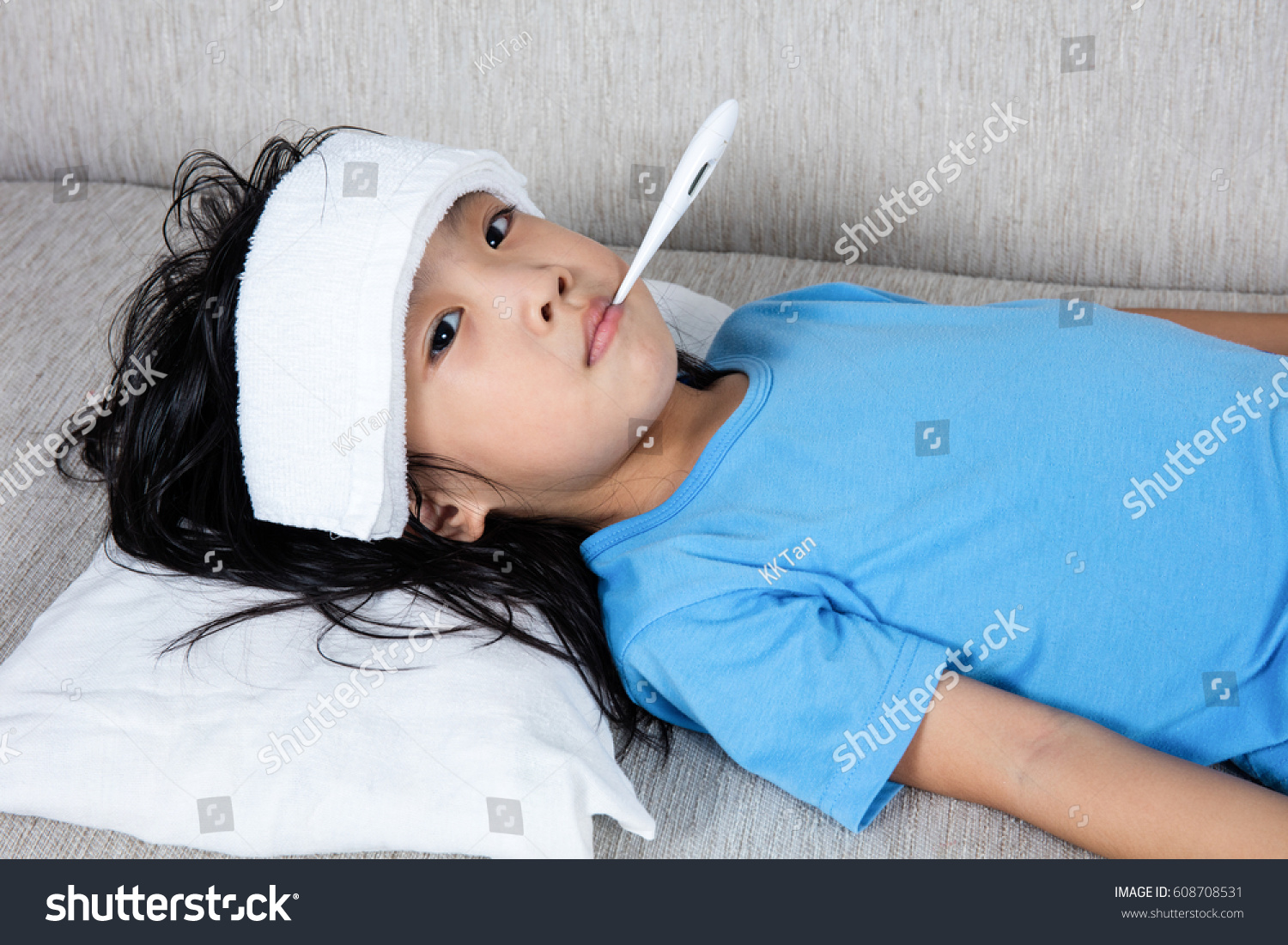 Asian Chinese little girl getting measurement for fever temperature at home.