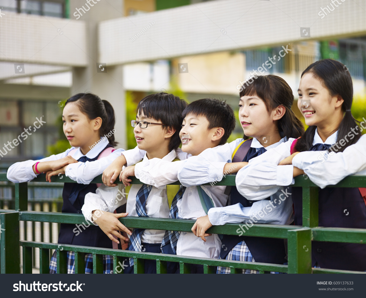portrait of a group of happy and smiling elementary school students in uniform.