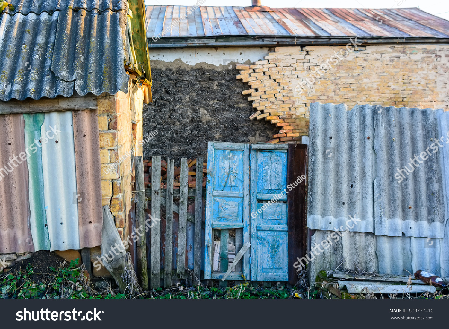 Abandoned rustic house with damaged wall and door