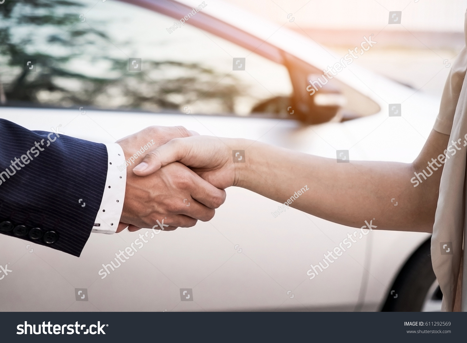 Close-up image of a firm handshake after a successful deal of buying a car.
