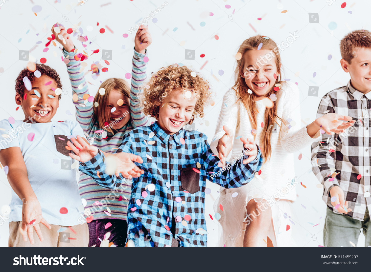 Happy kids throwing colorful confetti in a room