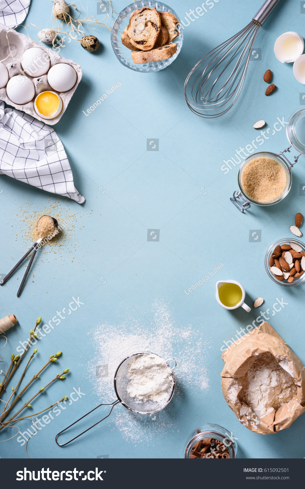 Bakery background frame. Fresh cooking ingredients - egg  flour  sugar  butter  nuts over blue background. Spring cooking theme. Top view  copy space.