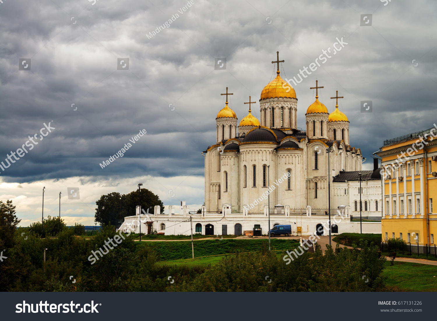 Vladimir Russia. Church the Assumption Cathedral of Vladimir in summer Russia. One of the landmarks during the sightseeing Golden Ring Tour. Green grass and trees at the background. Sky with clouds.