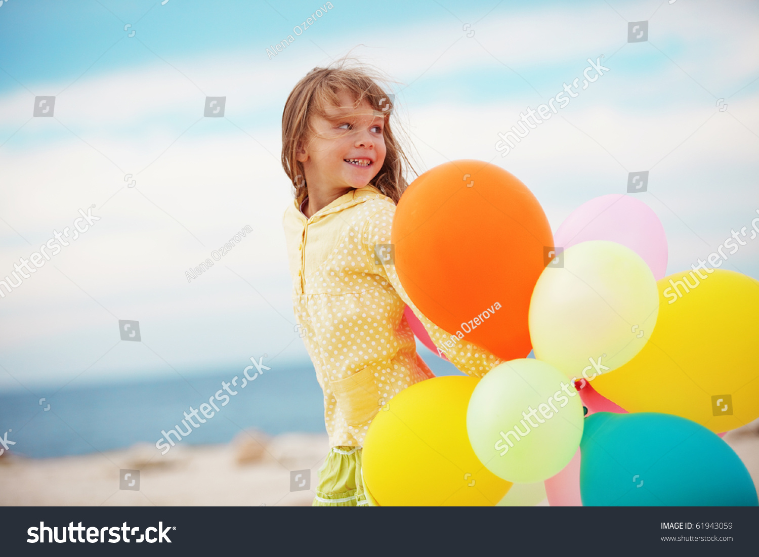 Portrait of little girl playing with air balloons at the beach