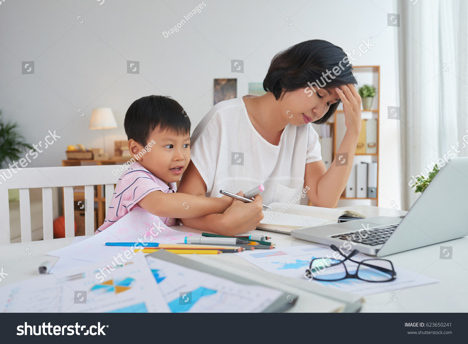 Little boy interfering with work of his mother