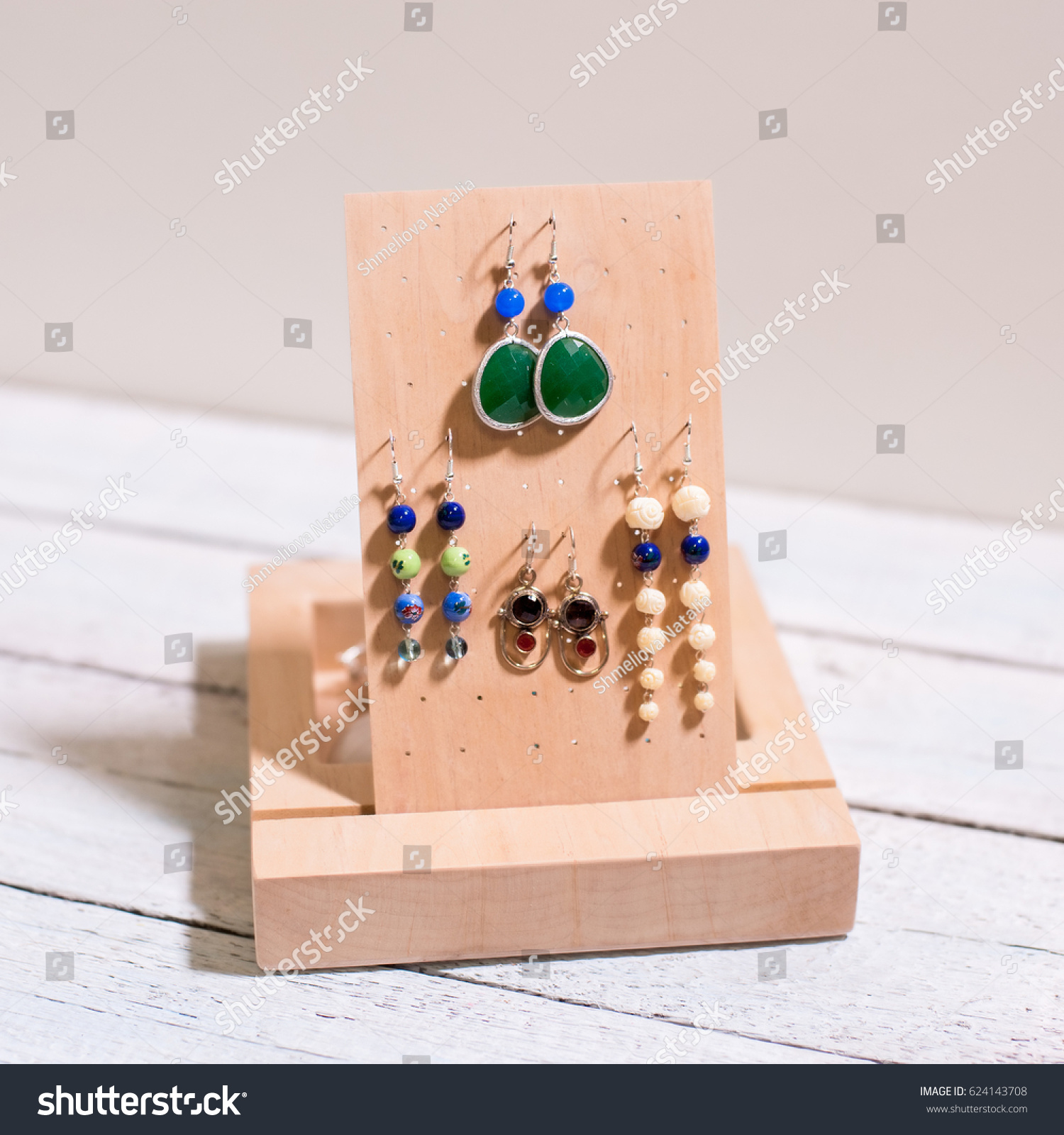 beautiful handmade wooden earrings stand on white background