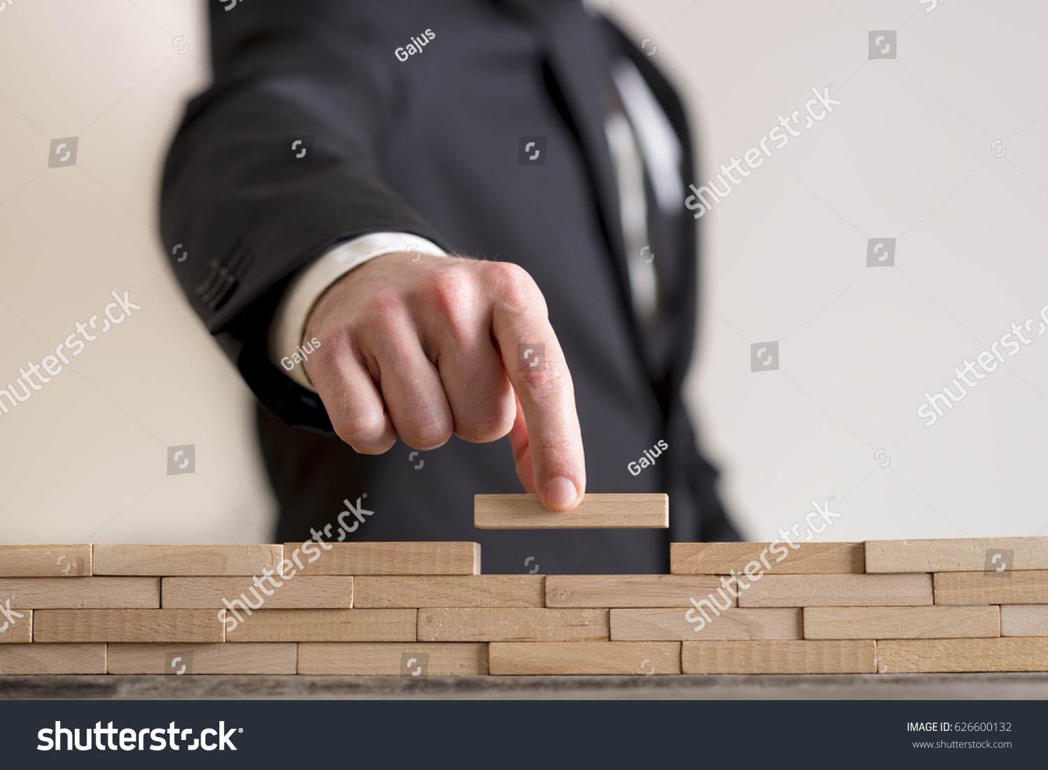 Concept of business strategy-  businessman placing wooden blocks on table.