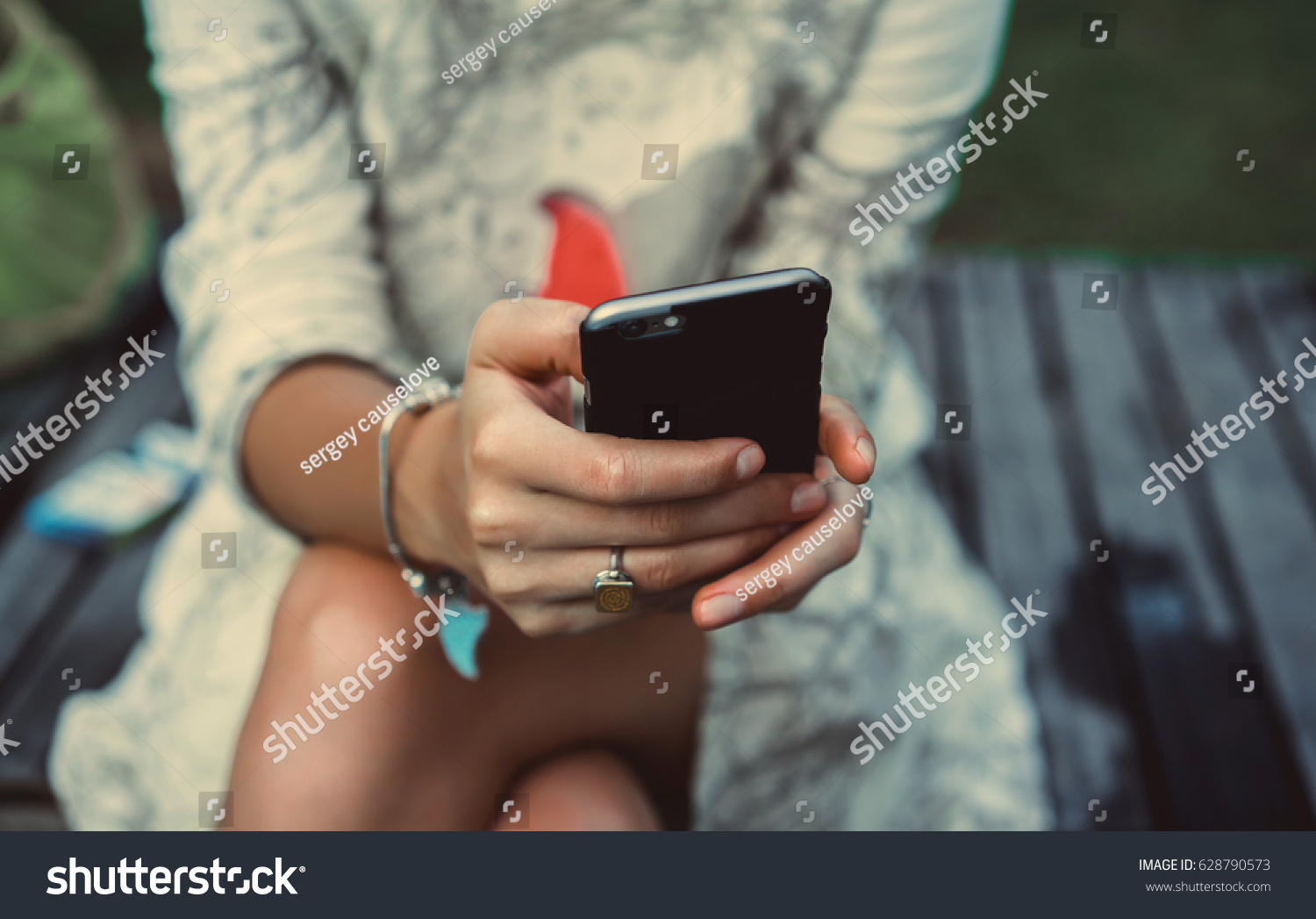 Close up of women's hands holding cell telephone with blank copy space scree for your advertising text message or promotional content hipster girl watching video on mobile phone during coffee break