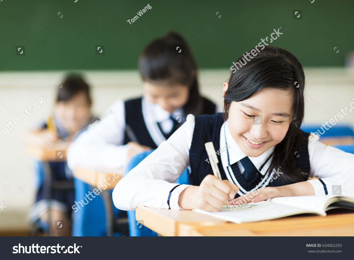smiling student girl in classroom and her friends in background