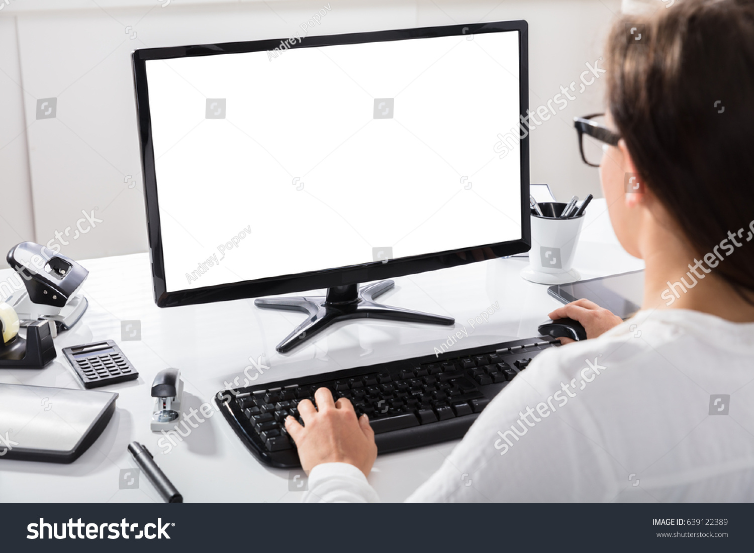 Close-up Of A Businesswoman Using Computer With Blank Screen At Workplace