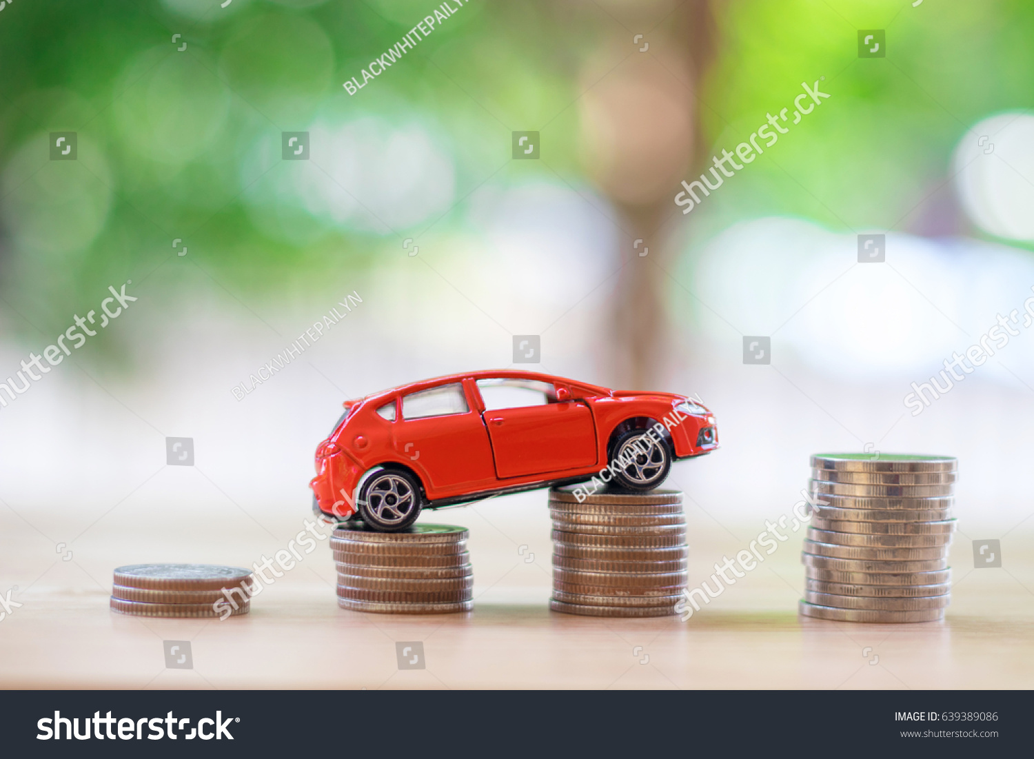 Red car over a lot of stacked coins. car insurance concept