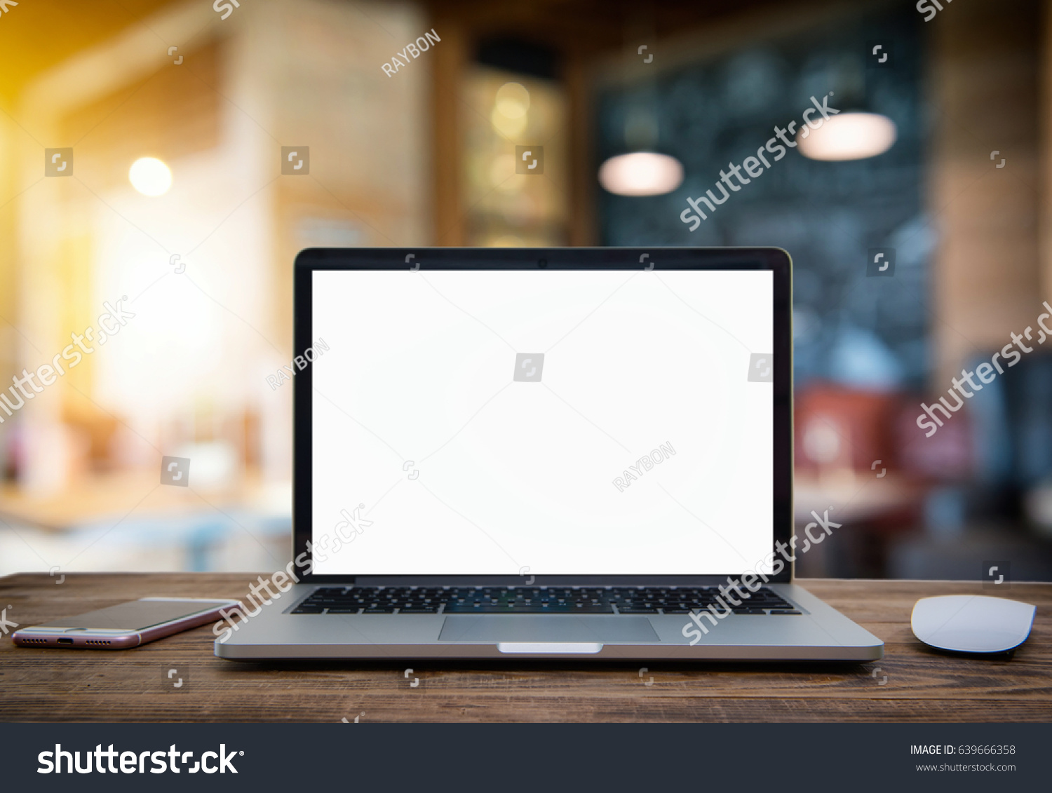 Laptop with blank screen on table of coffee shop blur background with bokeh.