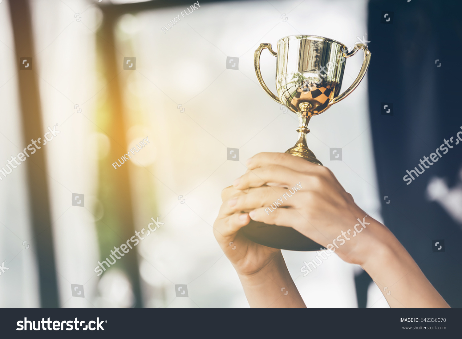 Teenage girls' hands are holding trophies  congratulations on success.Conception of victory in the competition.Focus on the trophy