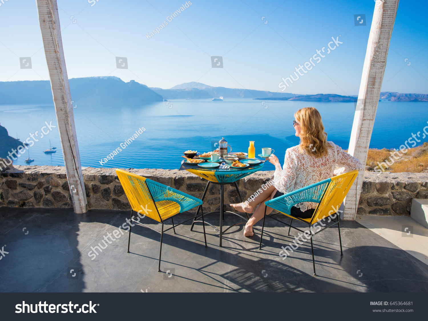 Woman enjoying breakfast with beautiful view from terrace