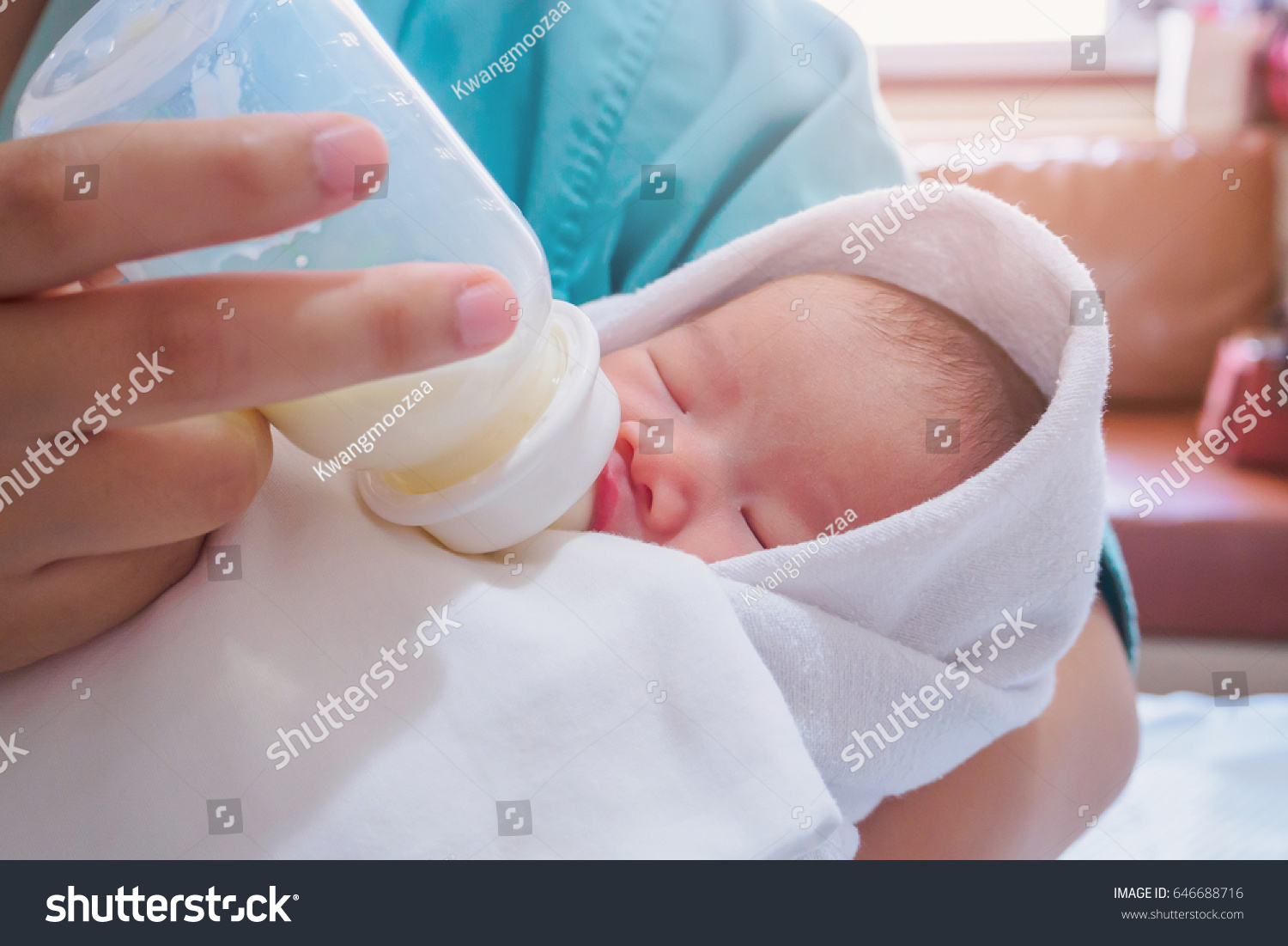 Mother feeding newborn baby from the bottle