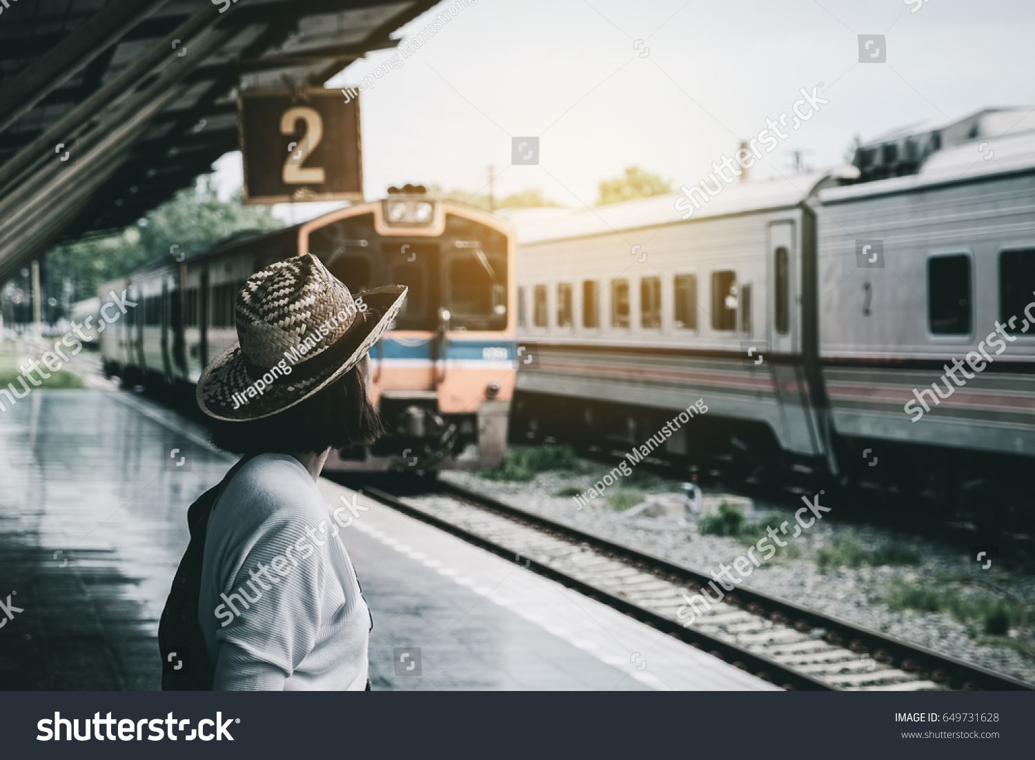 Summer travel hipster travel are Waiting for the train at the platform of railway station. travel concept.
