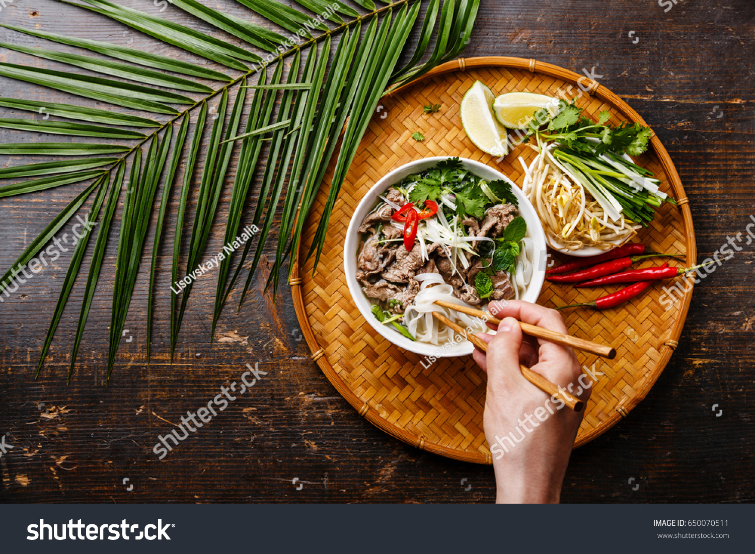 Pho Bo vietnamese Soup with beef and chopsticks in male hand copy space