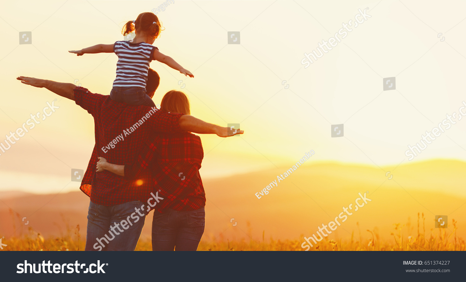 Happy family: mother father and child daughter on nature  on sunset