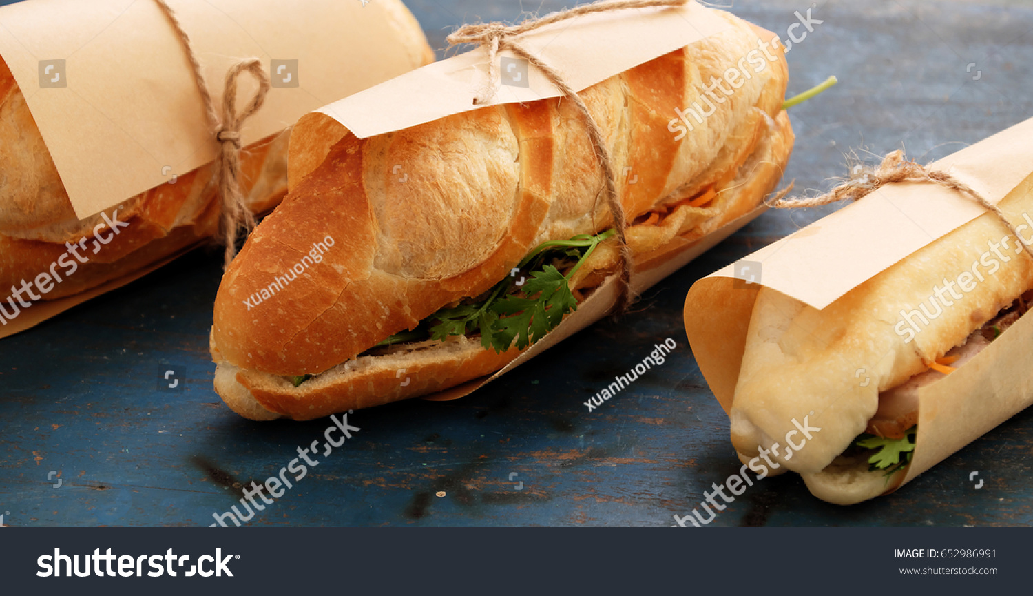 Famous Vietnamese food is banh mi thit  popular street food from bread stuffed with raw material: pork  ham  pate  egg and fresh herbs as scallions  coriander  carrot  cucumber  chilli.