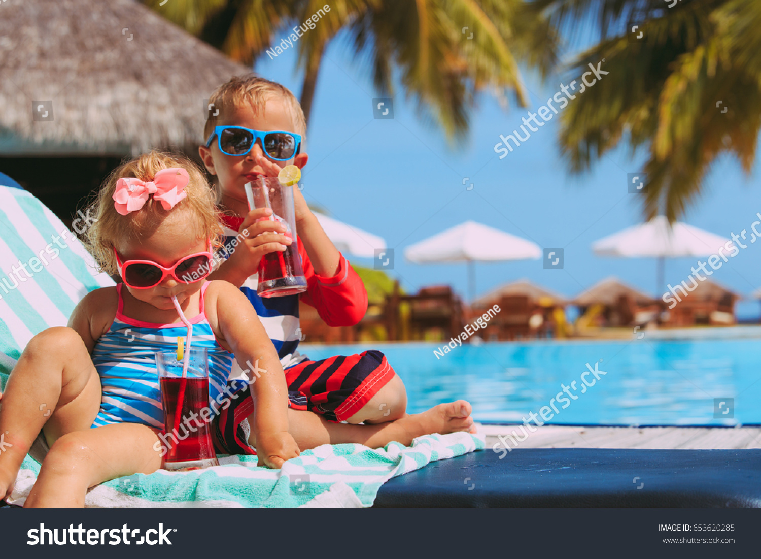 kids relax on tropical beach resort and drink juices