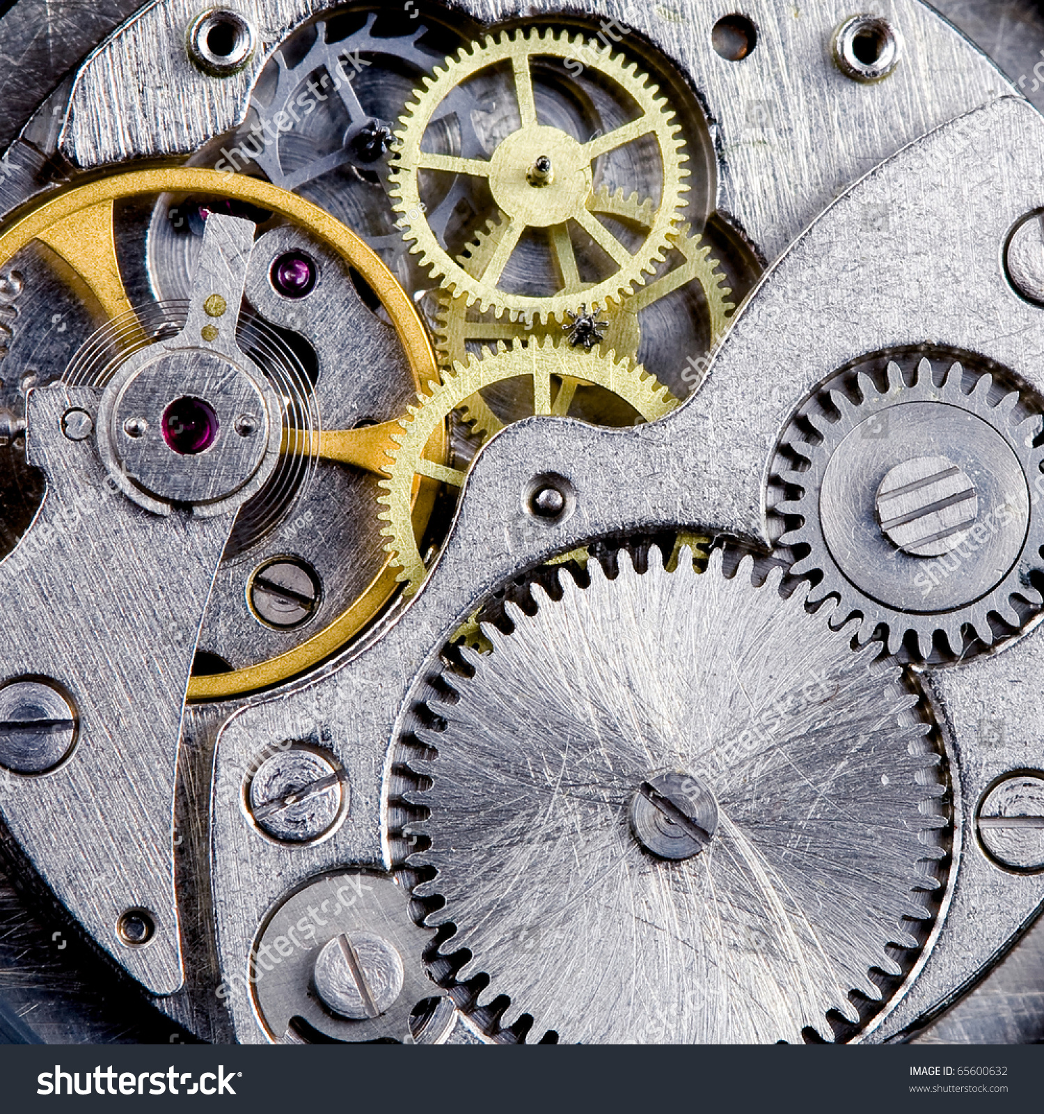 part of clockwork with gears spring ruby steel and brass