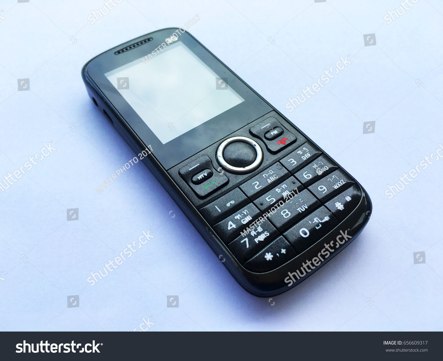 old 3G mobile Phone is button type on white paper background.
