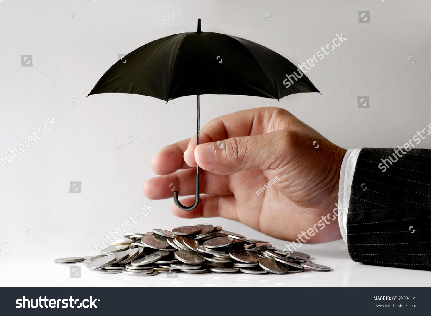 Businessman Protecting Coins With Umbrella. Financial safety Concept.