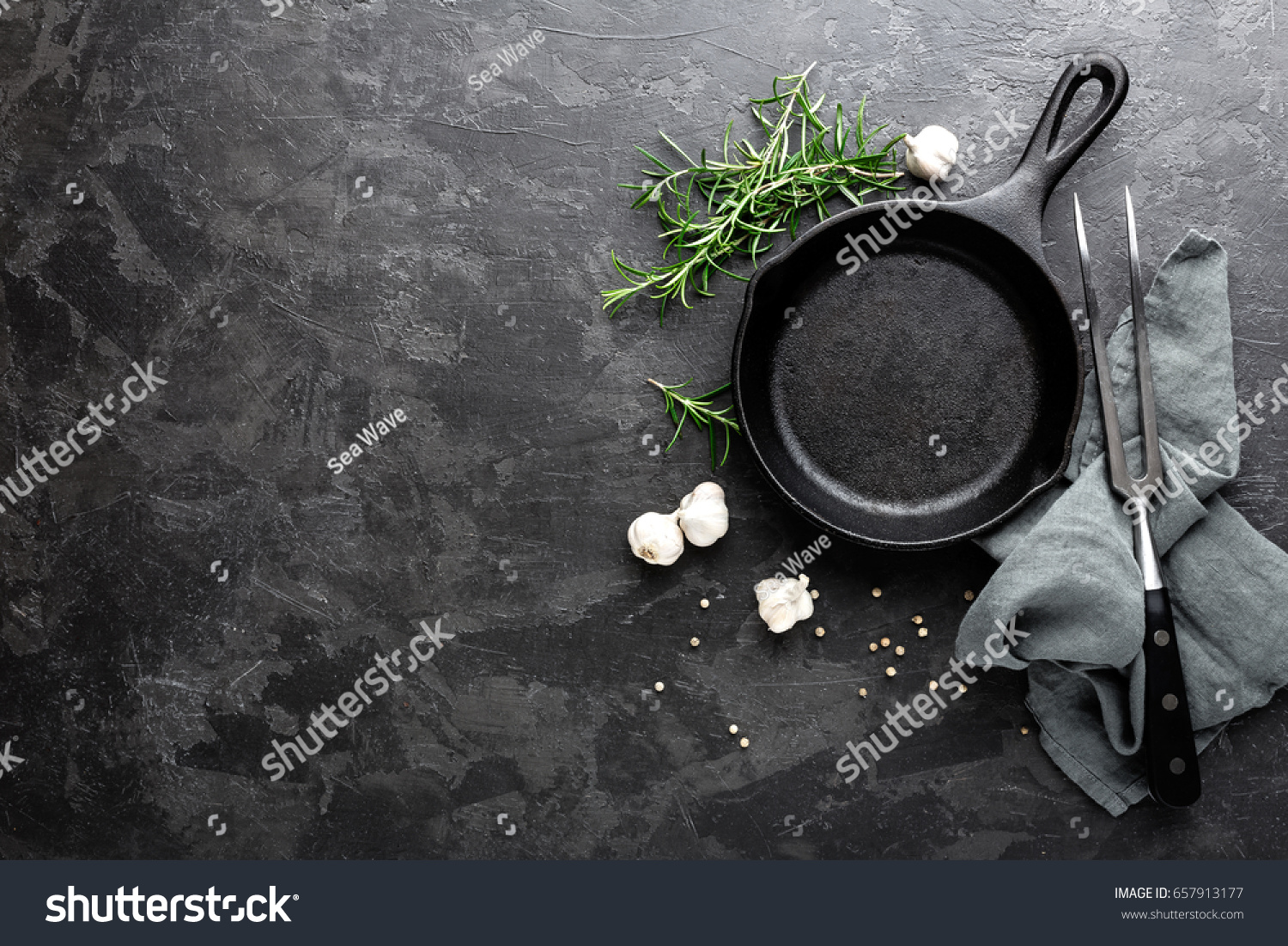 Empty cast iron frying pan on dark grey culinary background  view from above