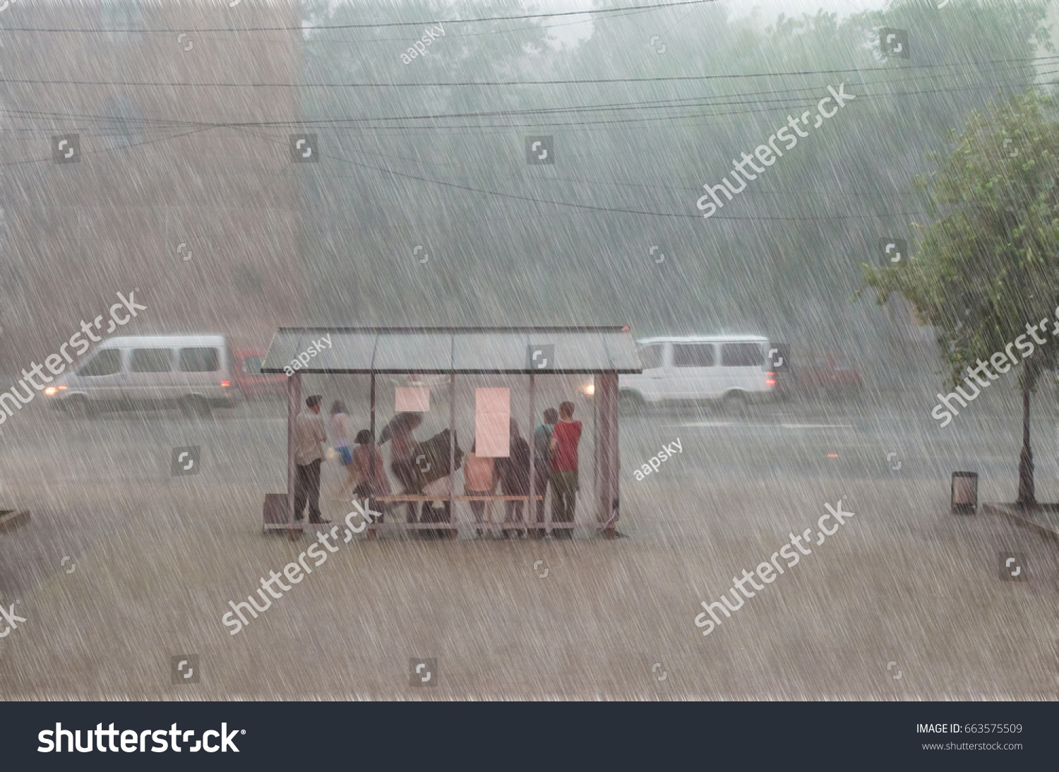 Crowd of people are hiding from heavy rain at a stop in the city