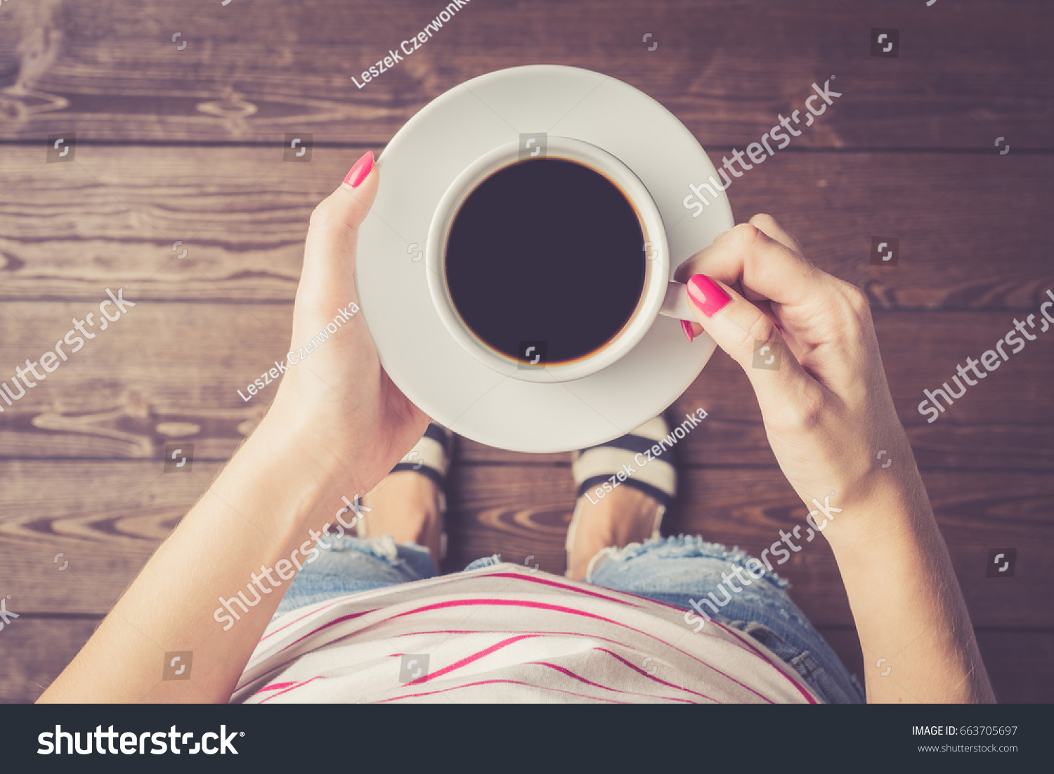 Woman holding cup of coffee. Top view
