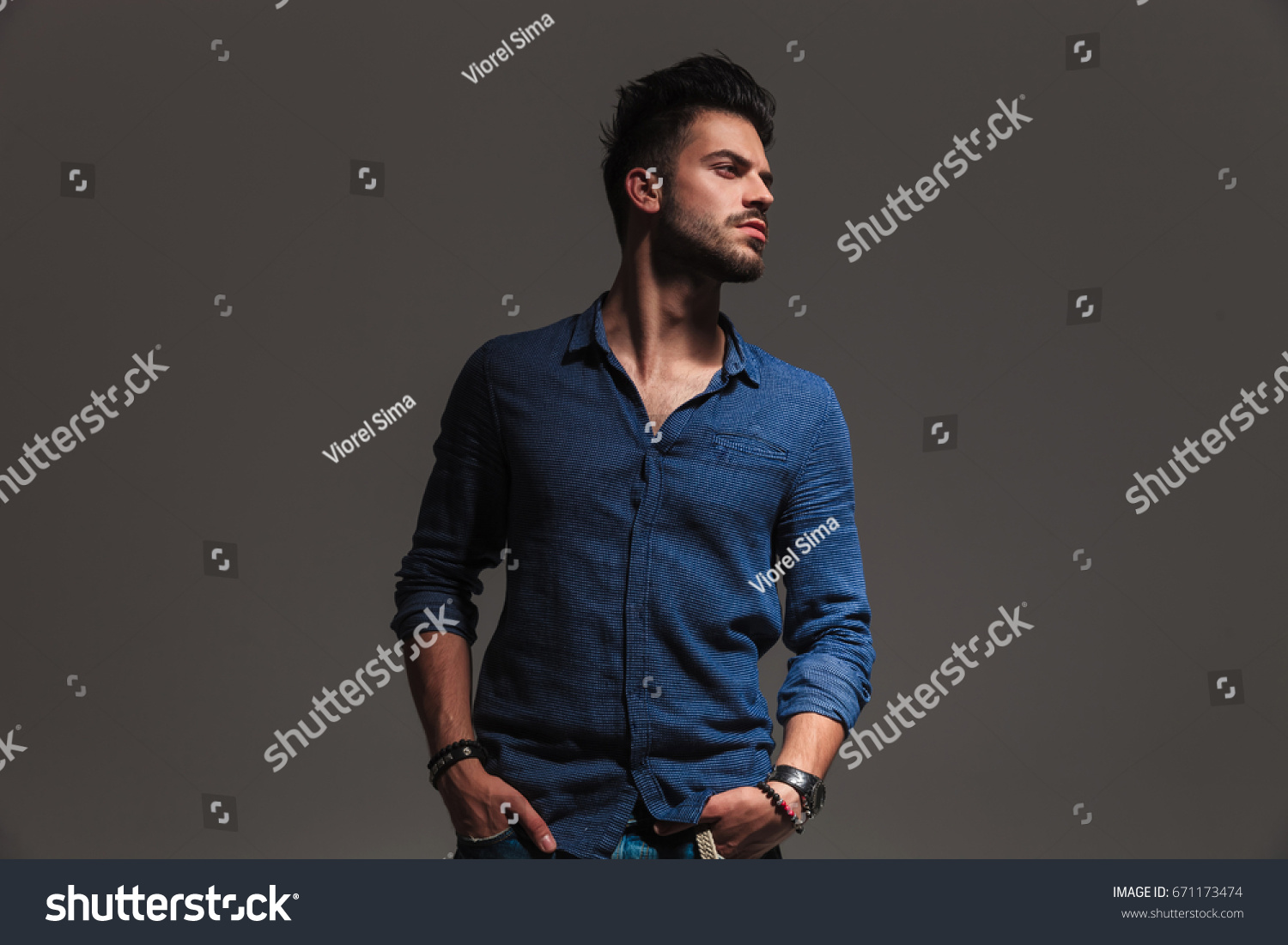 fashion casual man standing with hands in pockets and looks to