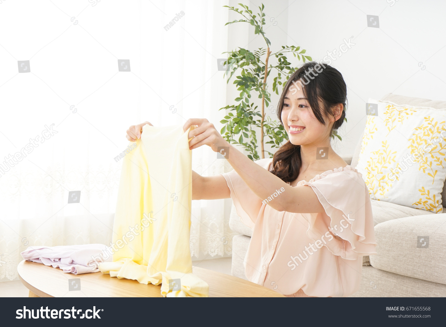 Young woman folding her clothes