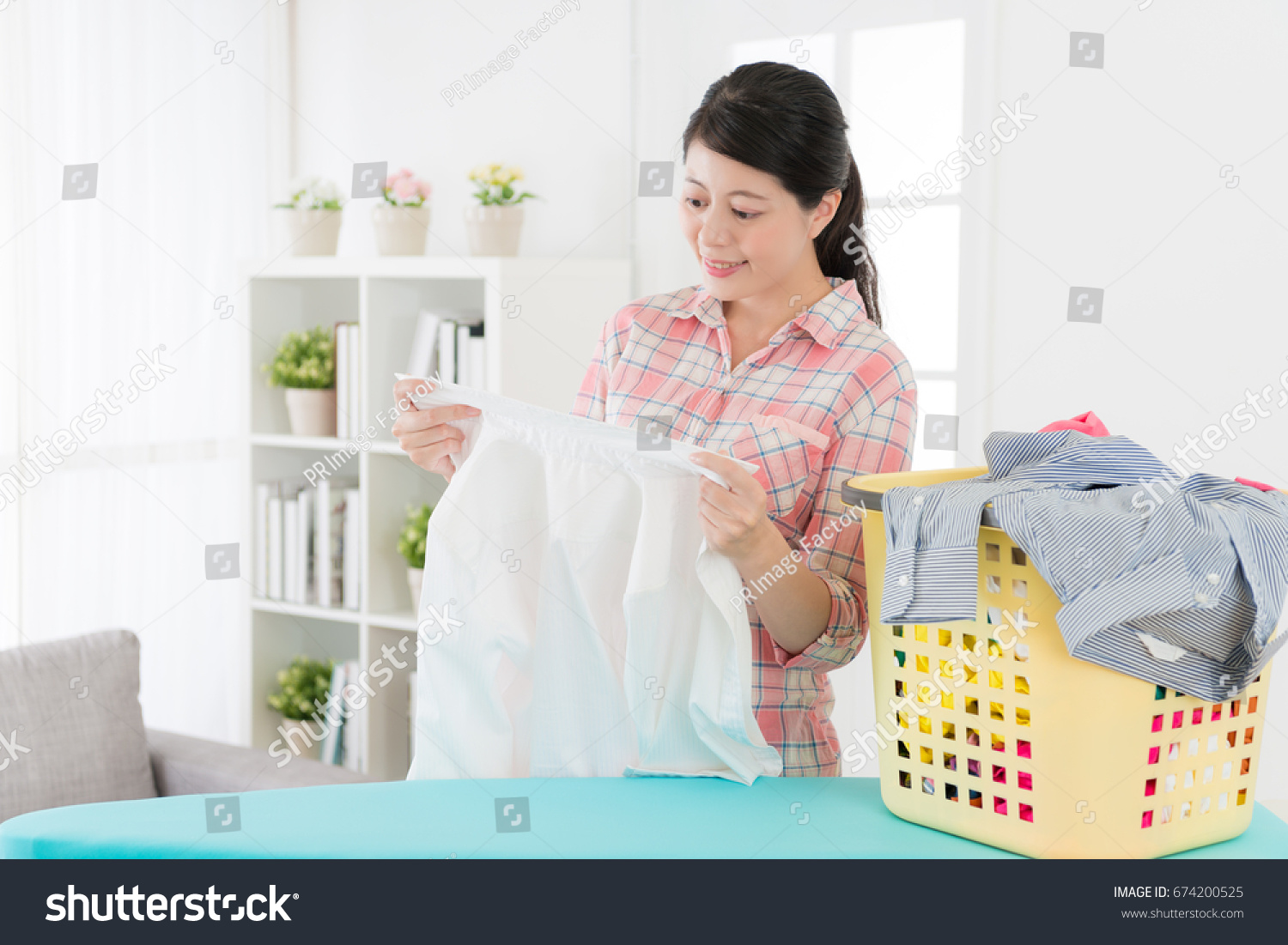 happy smiling mother looking at white shirt feeling satisfaction when her family clothing getting clean from laundry store.