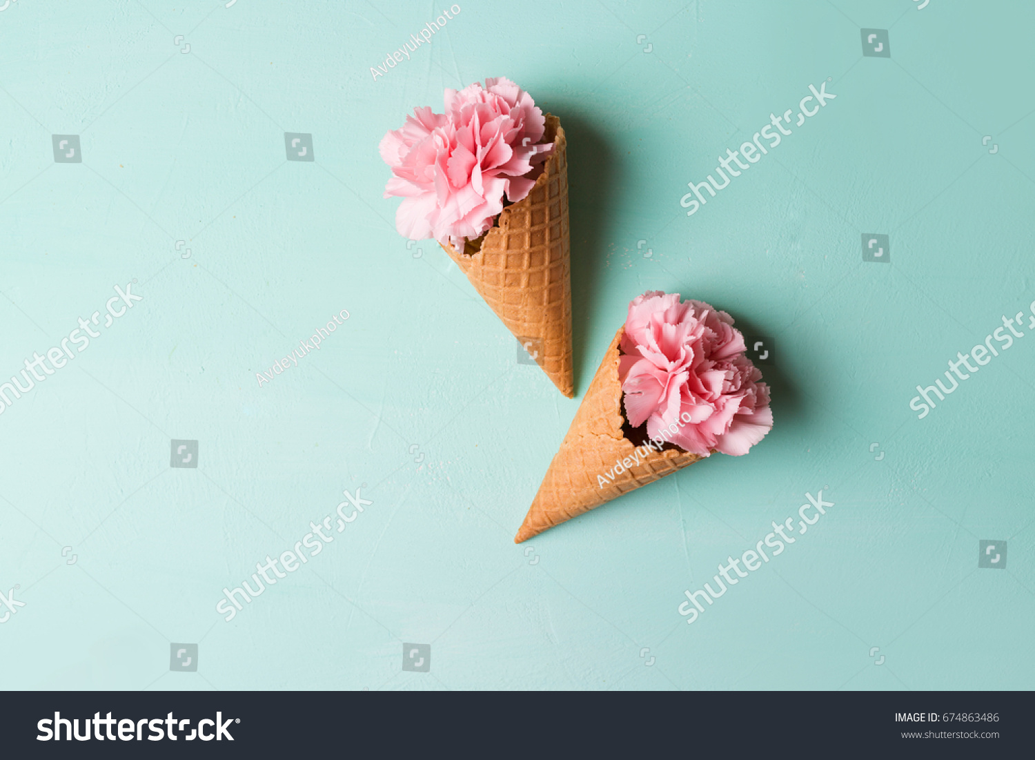 Pink carnations in waffle cones on a green background. 