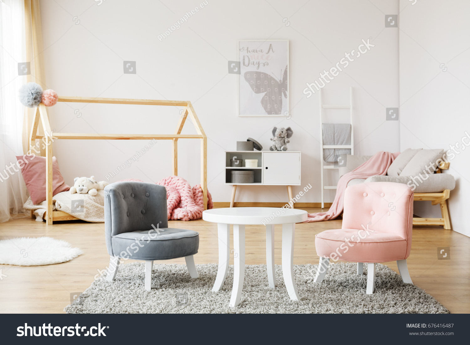 Grey and pink small cute chairs standing on soft carpet in cozy baby room