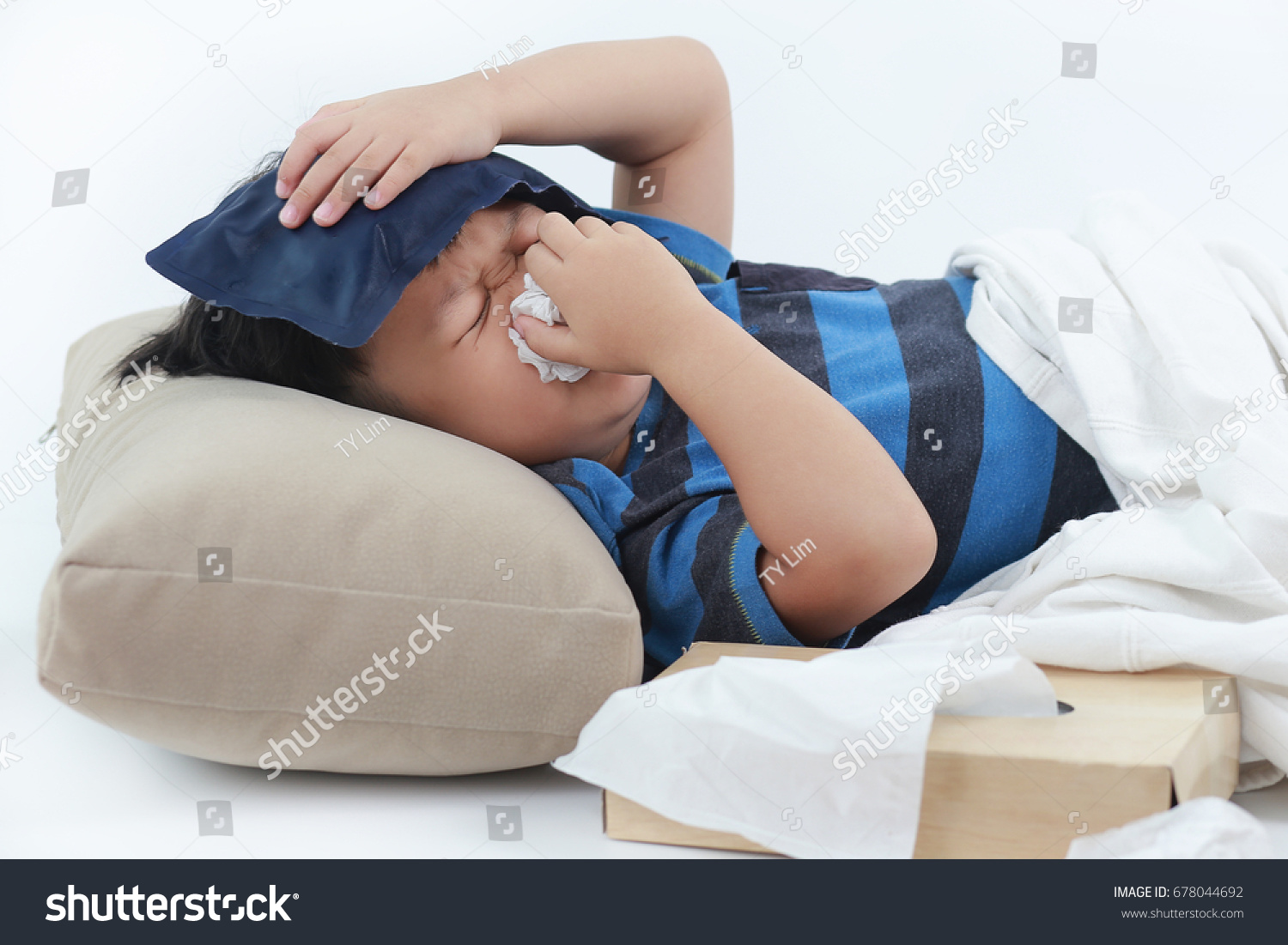 Little Asian sick boy fever and blowing her nose in bed