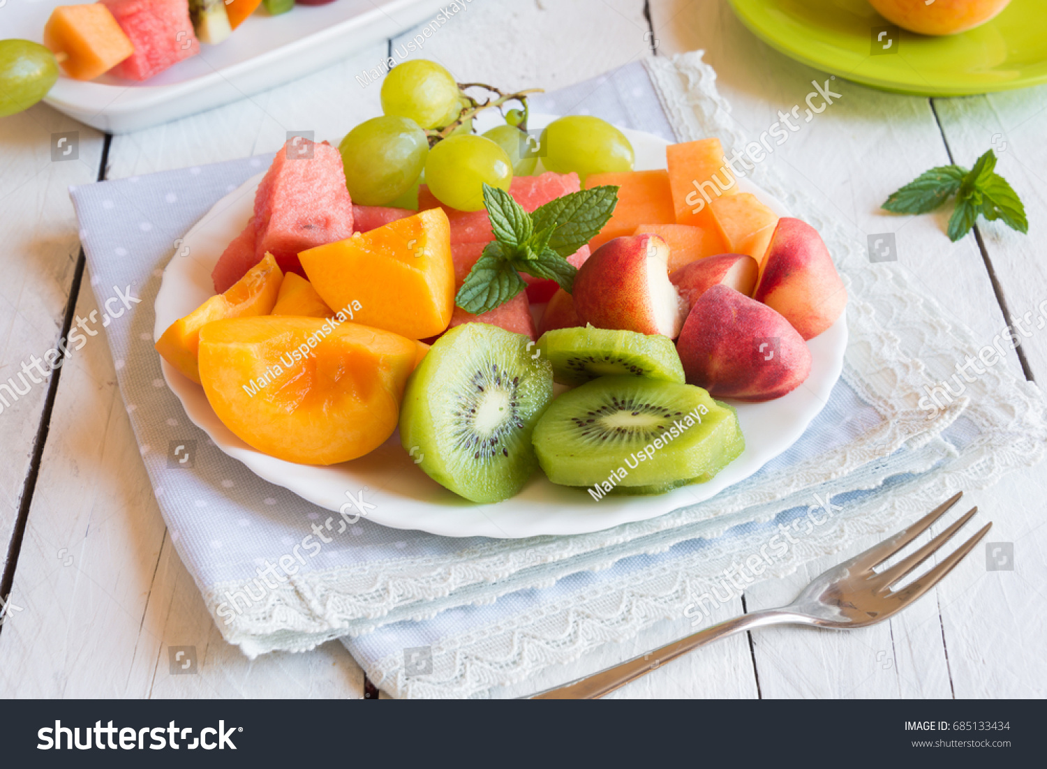 Fresh cut fruit (watermelon  kiwi  peach  melon) on white plate