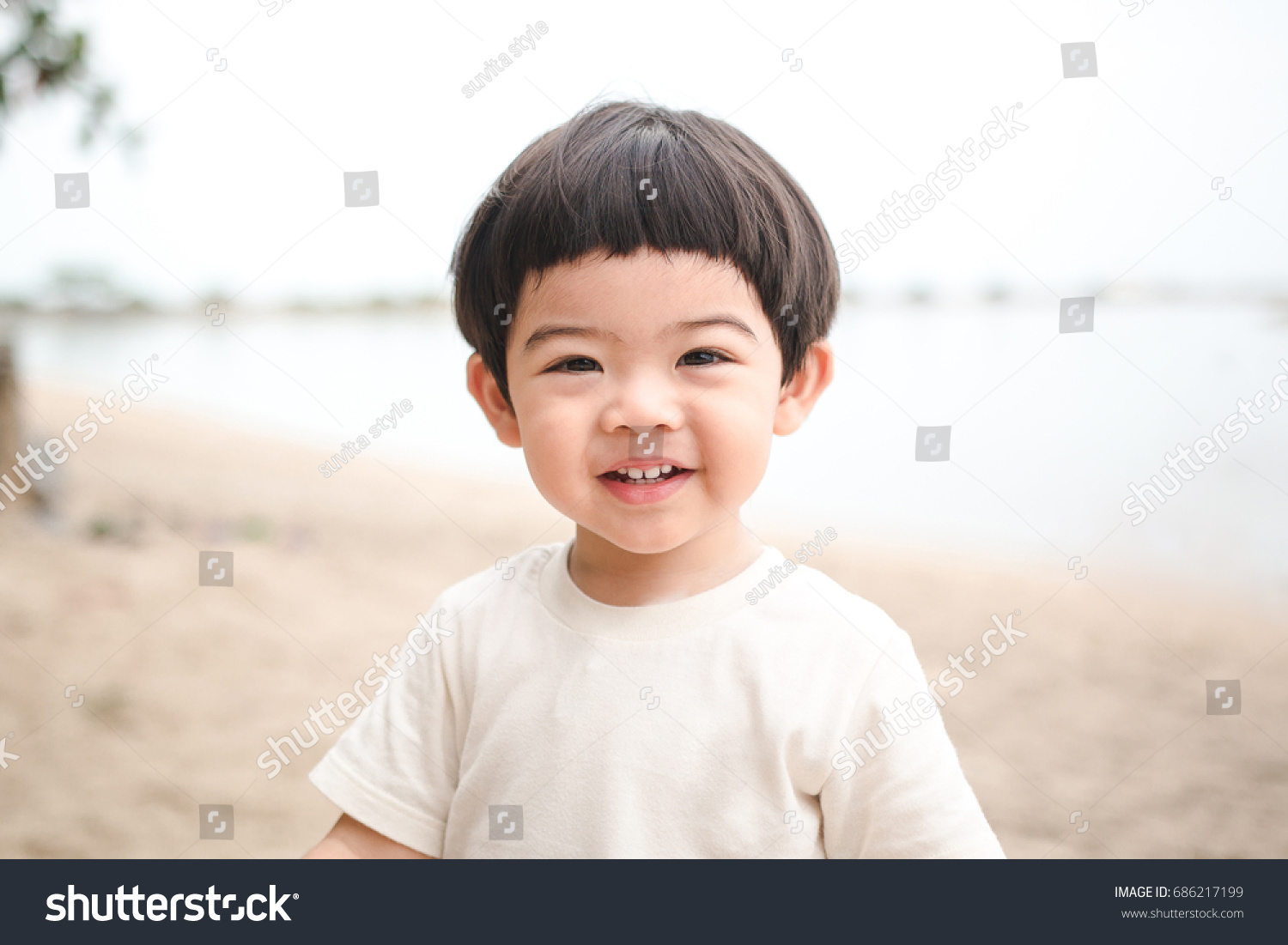 Portrait baby cute boy playing in the sandy beach  happy and Smiling child.