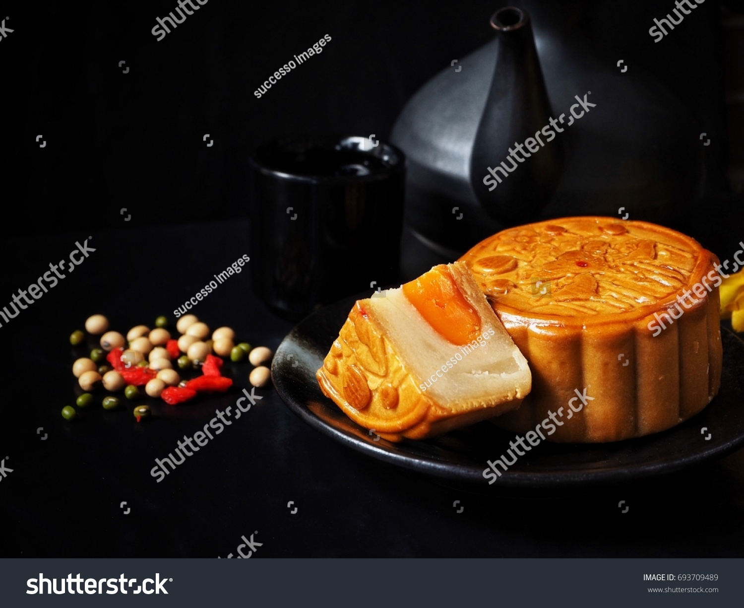 Festival moon cake with hot tea on black background