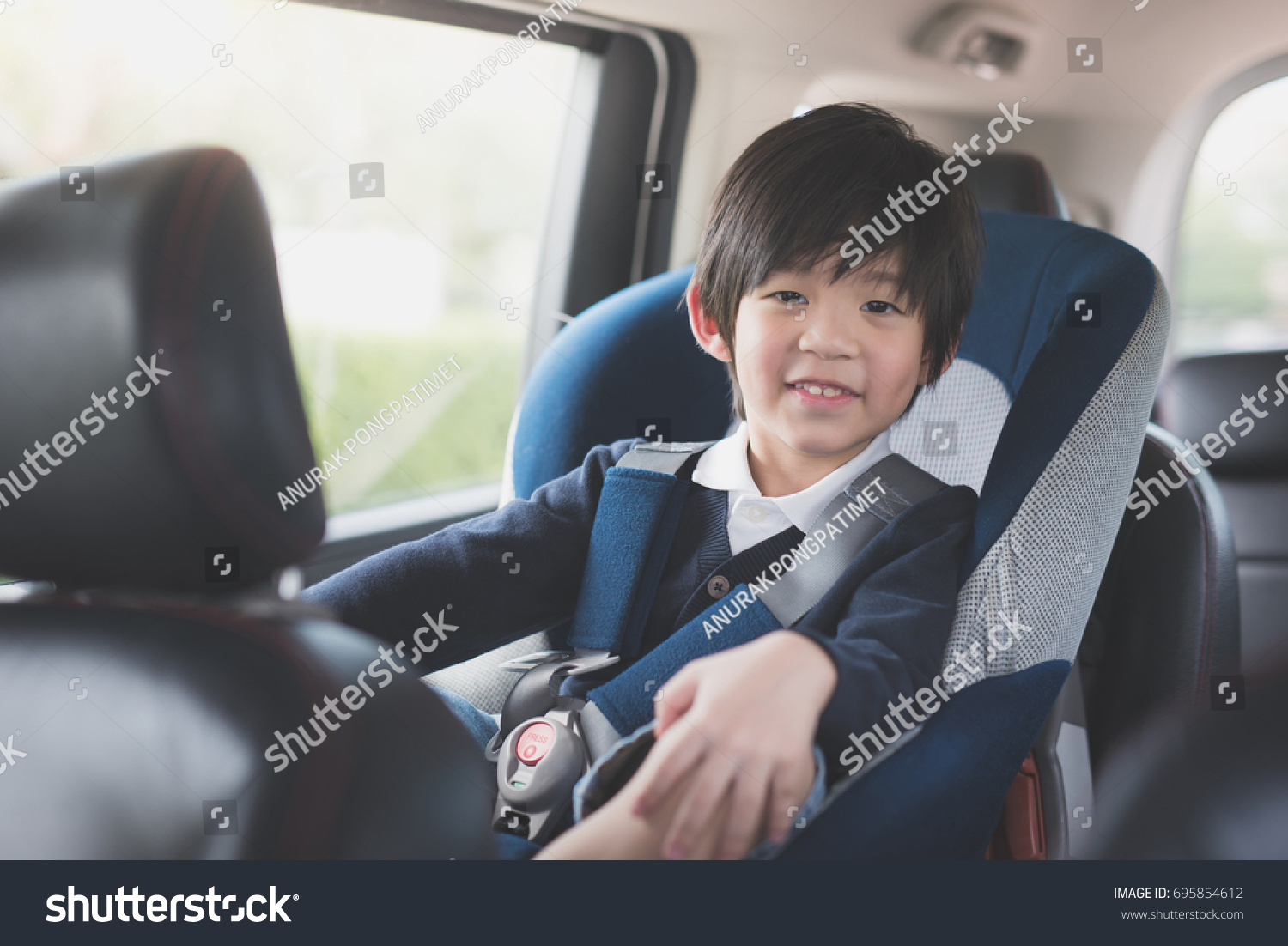Portrait of cute Asian child sitting in car seat