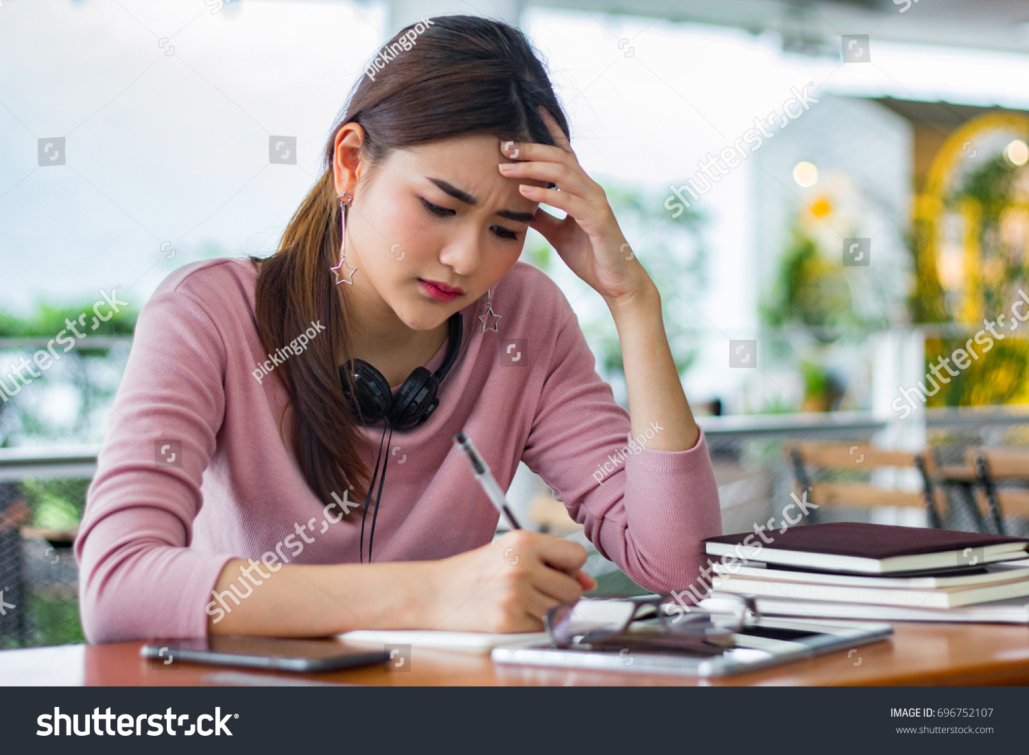 Female student reading a book for the exam or doing homework.young asian college student at hard exam.