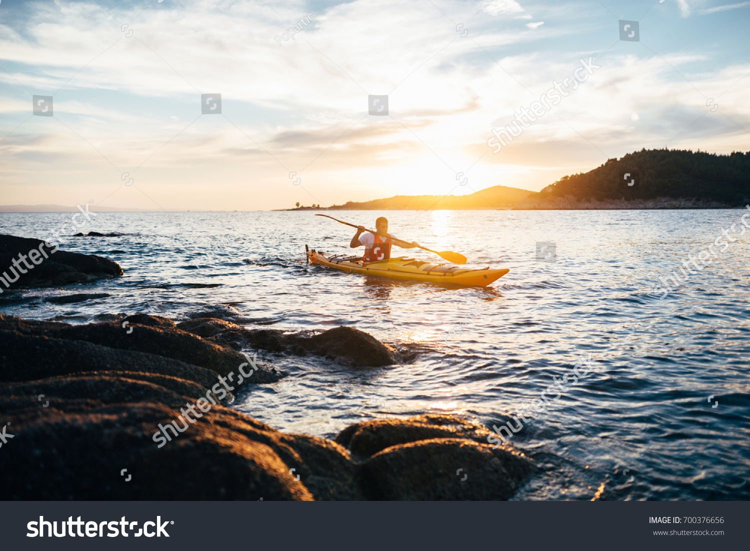 Kayaker paddling the kayak at sunset sea. Kayaking  canoe  paddling

