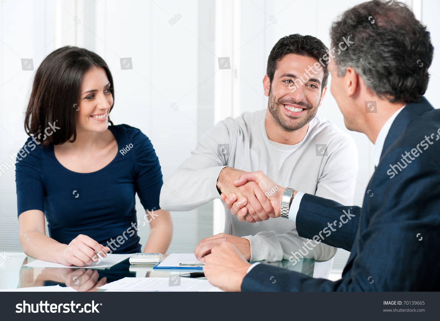 Happy couple seal a deal with their personal financial advisor at home