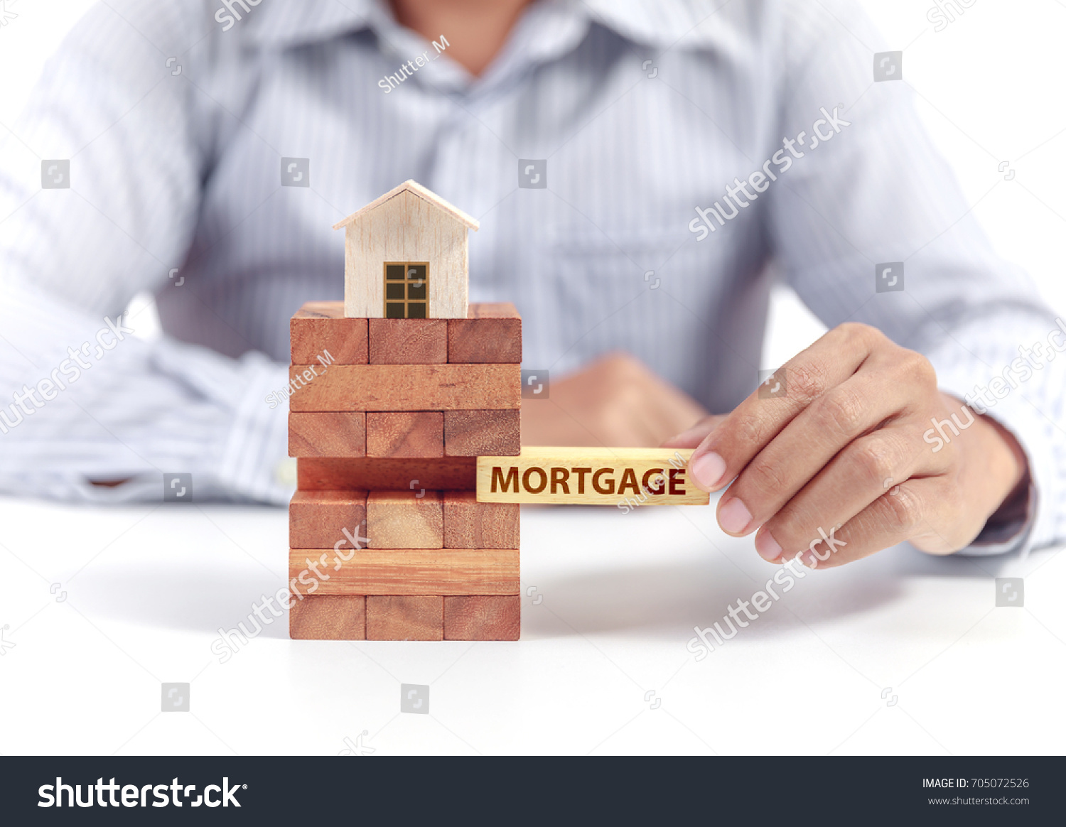 businessman hold word mortgage with wooden home model