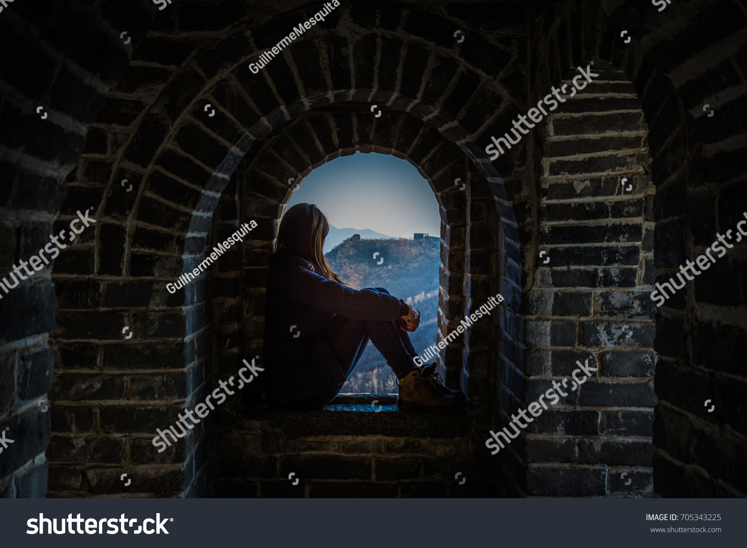 Tourist girl at a tower of the Great Wall of China. The Great Wall of China is the world's longest wall and biggest ancient architecture