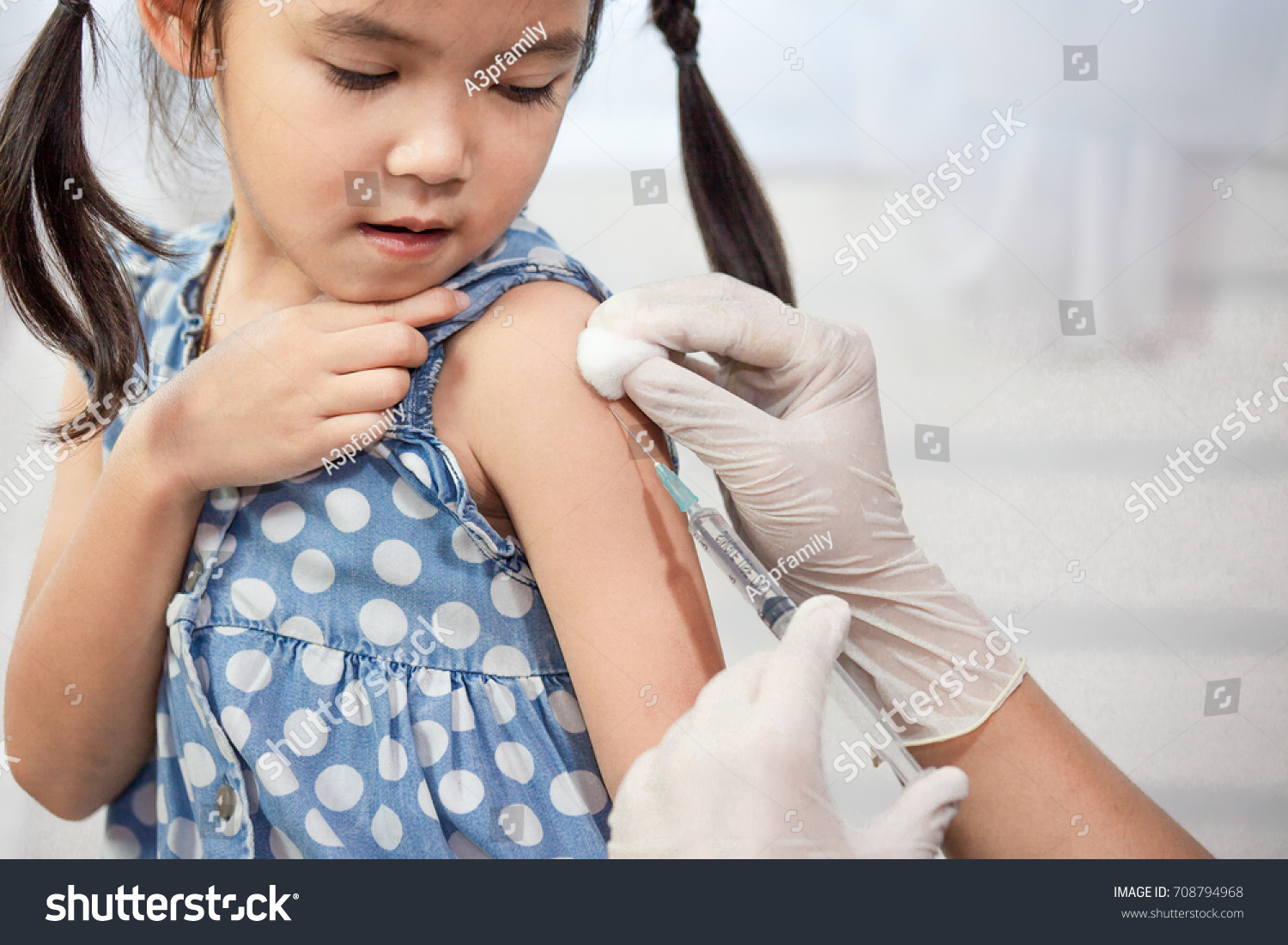 Doctor injecting vaccination in arm of asian little child girl healthy and medical concept