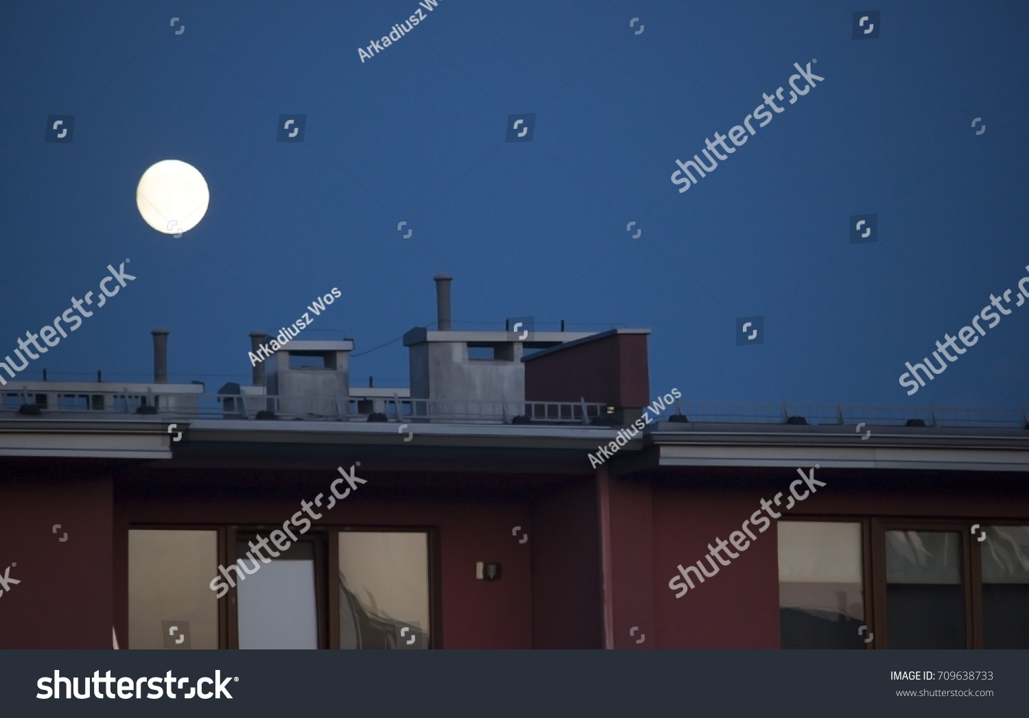 the roof of the flat block with the moon on the background