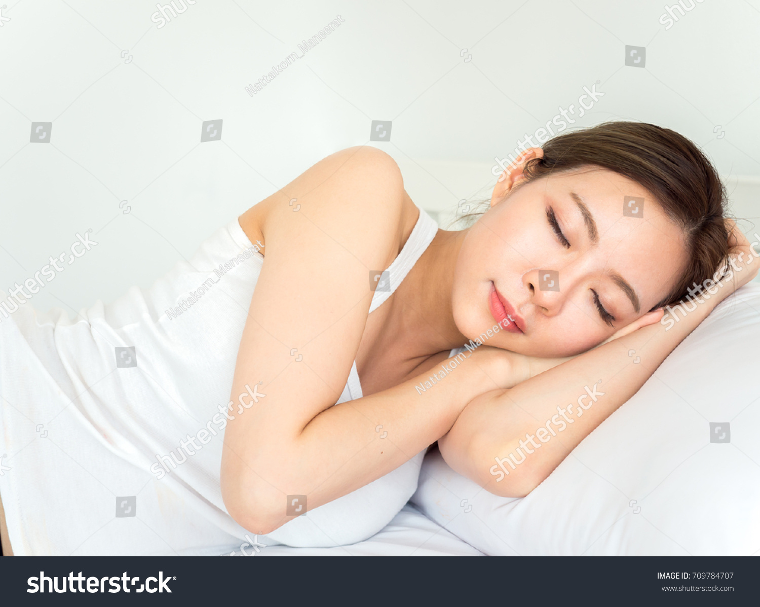 Young beautiful asian woman sleeping happy on white bed with happy feeling