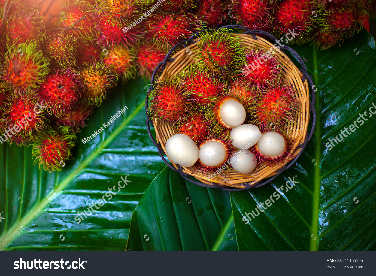 Fresh rambutans in a basket placed on a green leaf concept.
