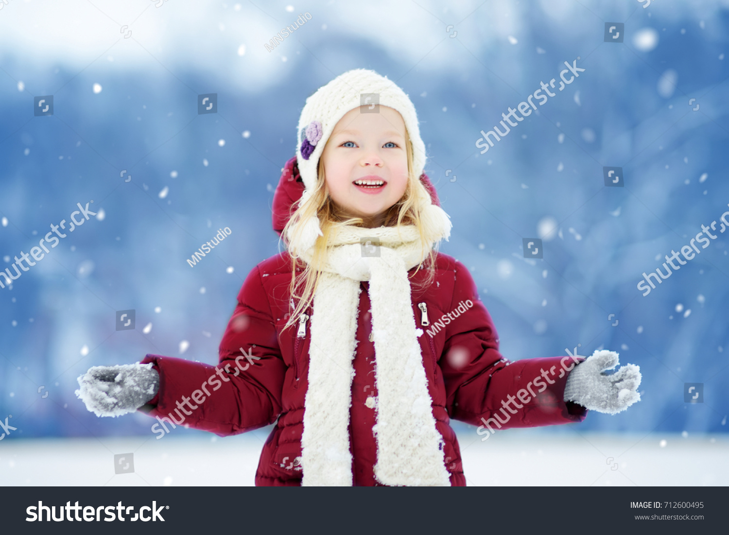 Adorable little girl having fun in beautiful winter park. Cute child playing in a snow. Winter activities for kids.